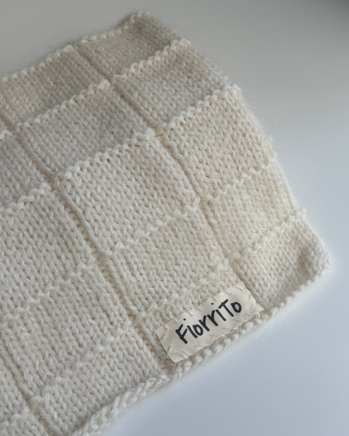 Knitted blanket with a 'Florito' label on a light gray background