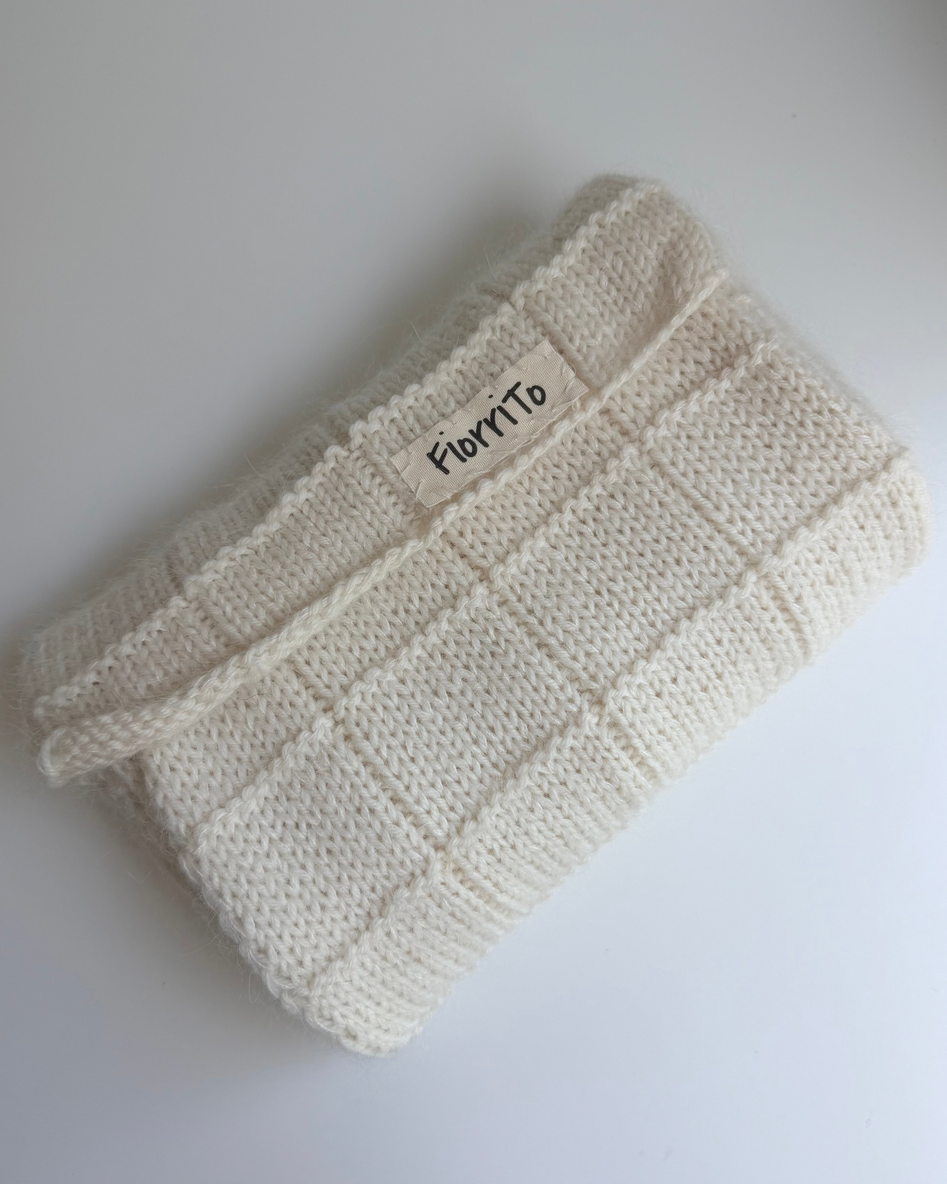 Knitted headband with 'Flore' label on a white background